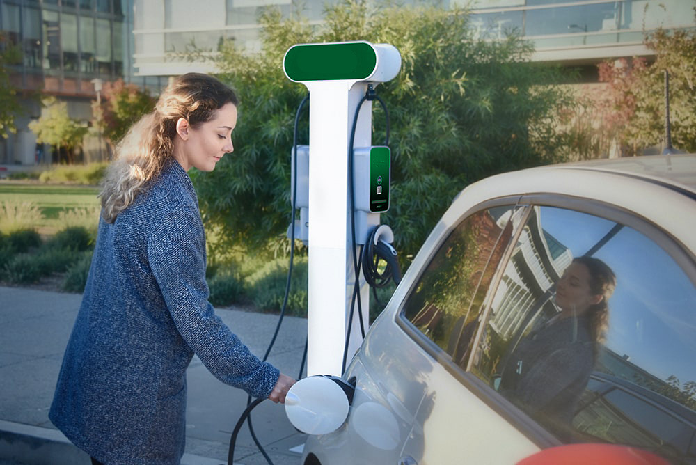 Image of women charging her EV using an JuicePedestal