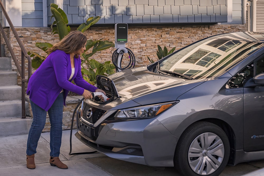 Image of women charging her EV using a Juicebox charger