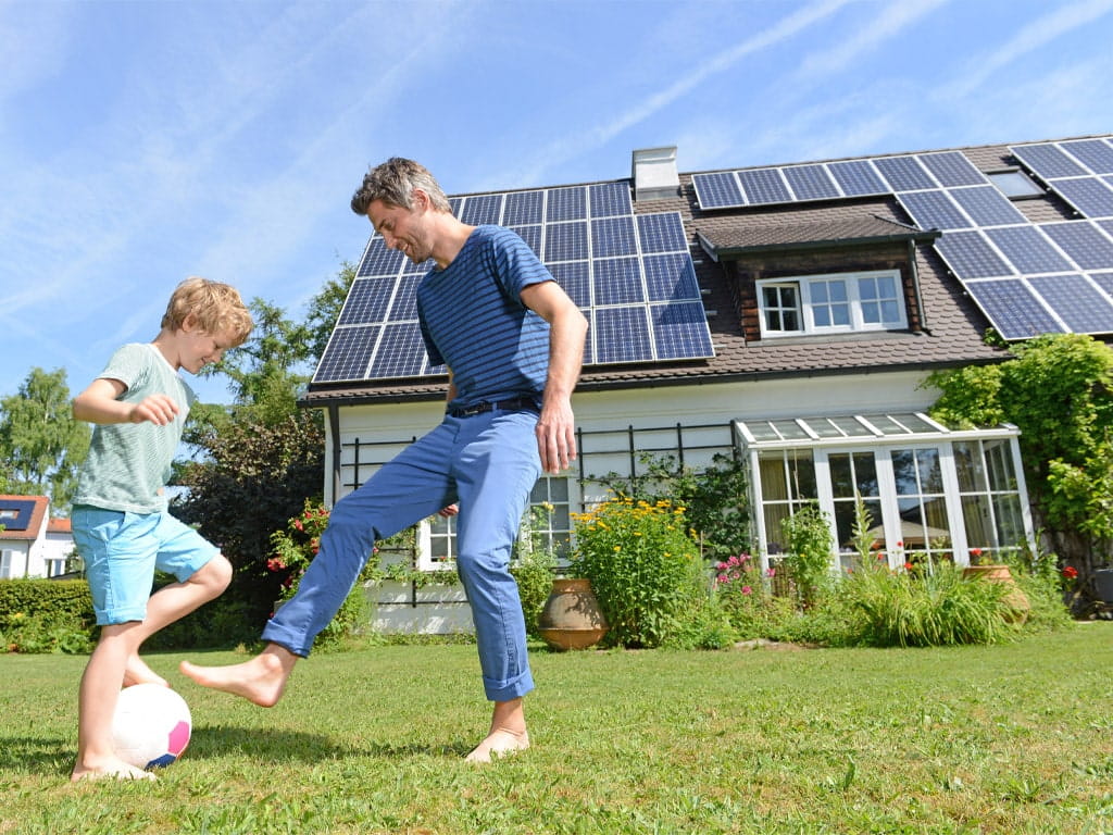 solar panels on a house with a parent and child playing outside